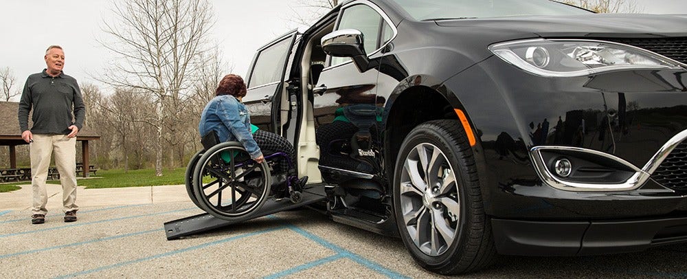 woman in wheelchair entering wheelchair van rental via side-entry ramp