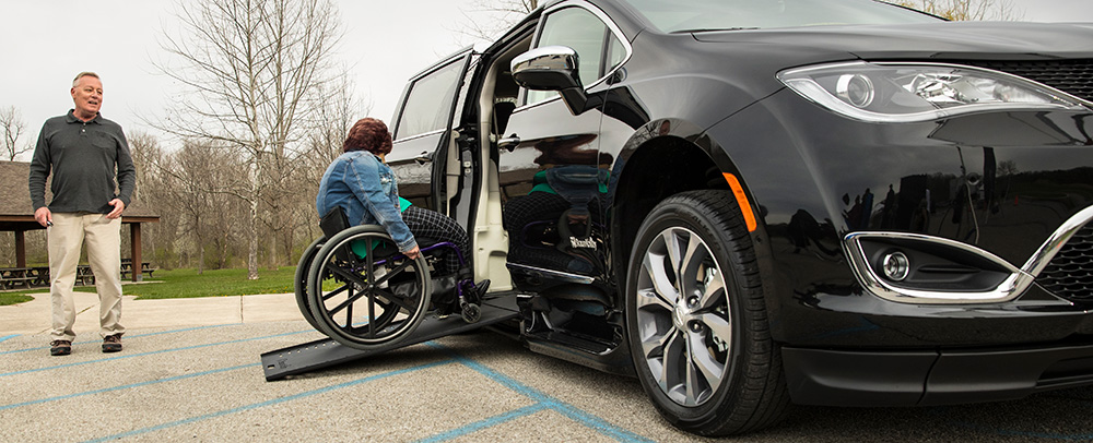 woman entering wheelchair accessible van rental via ramp