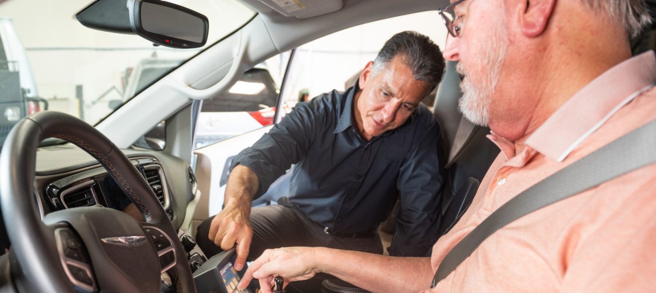 dealer showing customer how to use a wheelchair accessible van rental