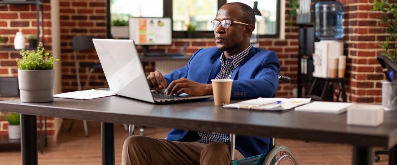 Man in a wheelchair using a labtop