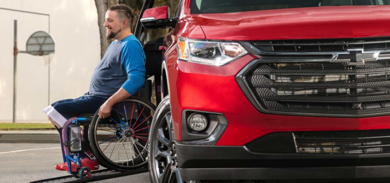 Man in a wheelchair using a ramp to get out of their Handicap Van