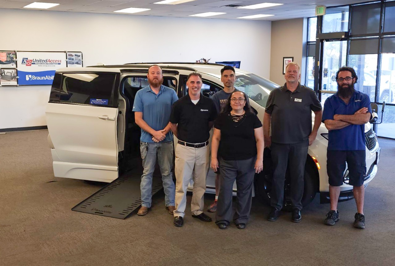 team members in front of wheelchair accessible van