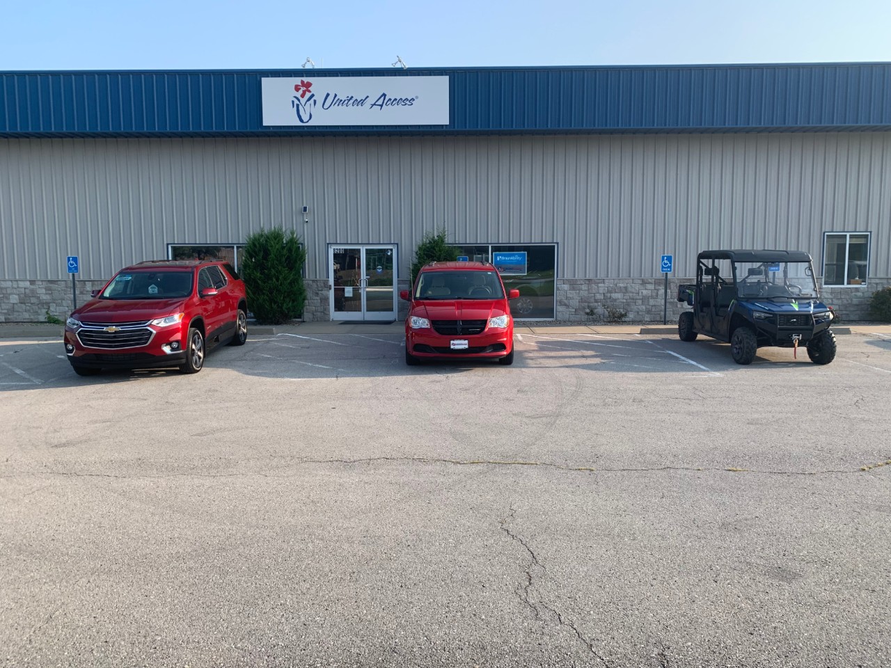 three wheelchair accessible vans parked in front of dealer entrance