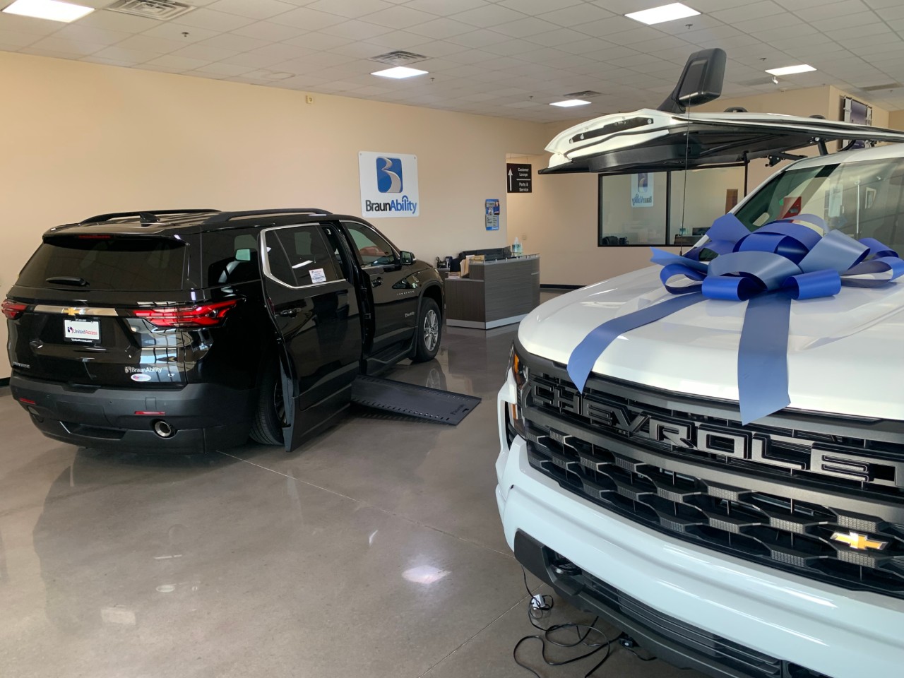 two wheelchair accessible vehicles one with a blue bow