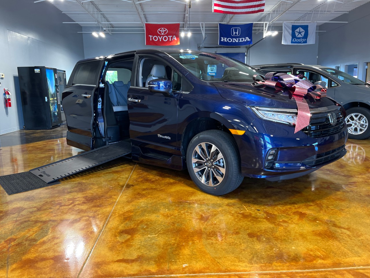 blue accessible van with bow and ramp deploy