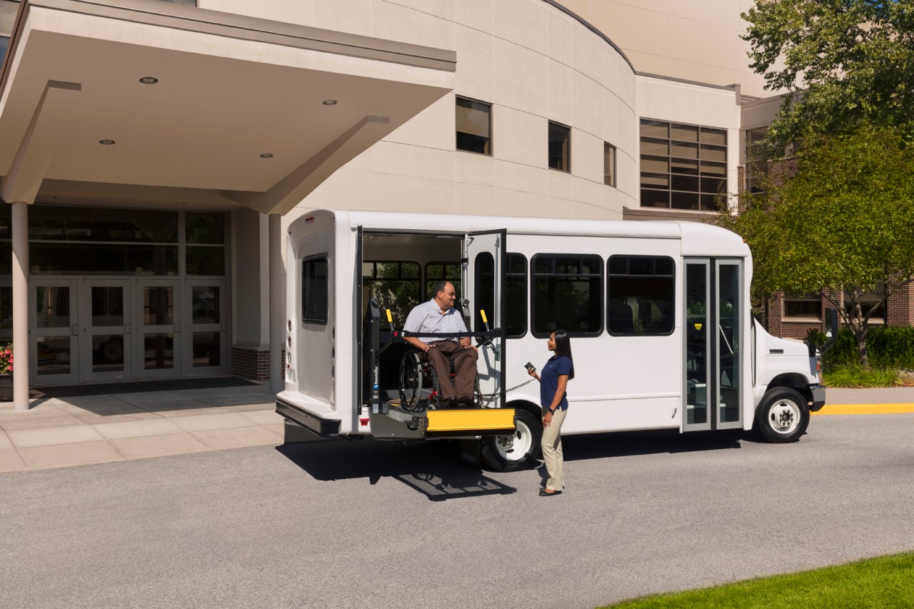 ADA Lifts side entry wheelchair lift in use white bus
