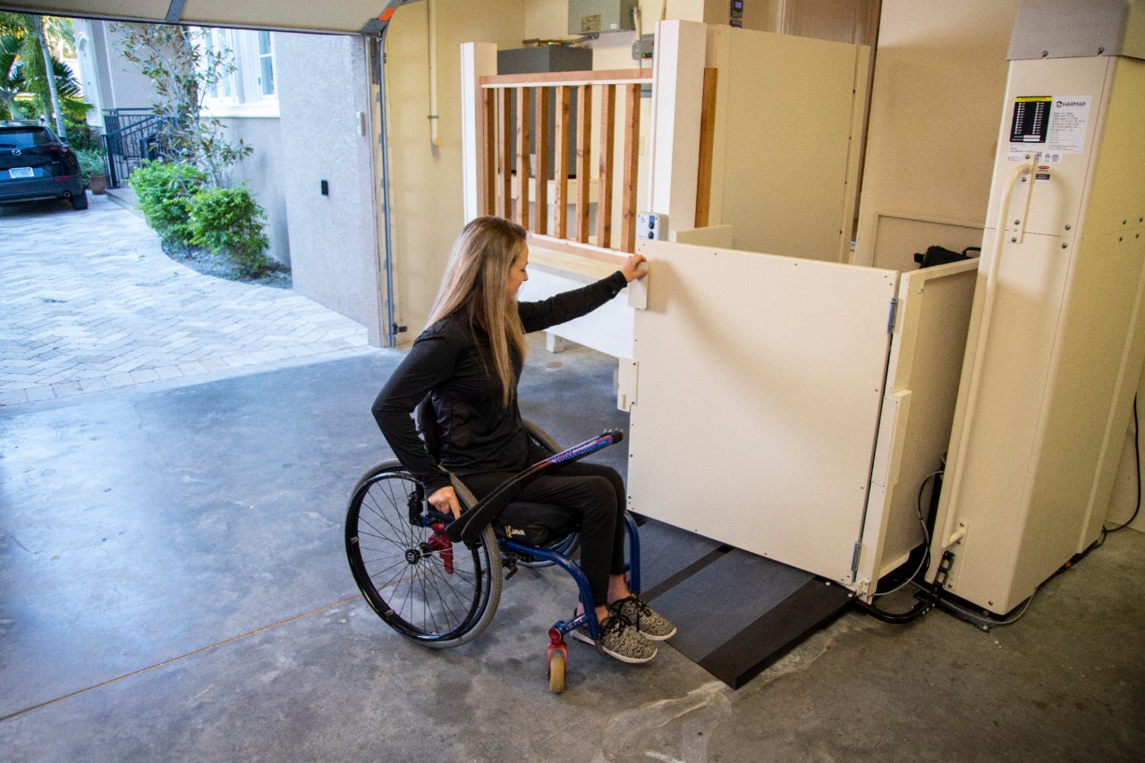 Harmar Highlander Vertical Platform Lift woman holding door